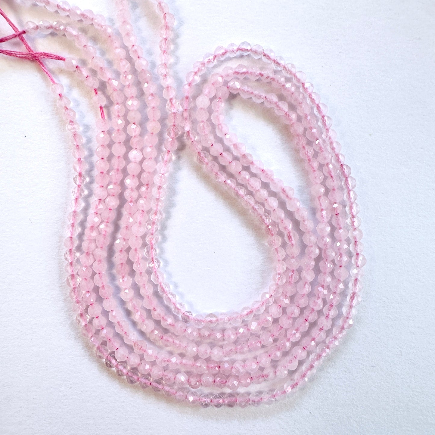 Close-up of Rose Quartz faceted rondelle beads with soft pink tones and sparkling finish.