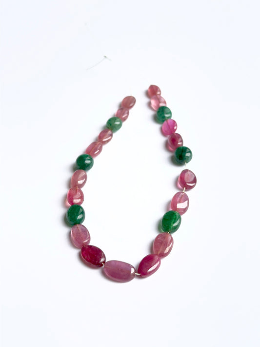 Close‑up of ruby and emerald smooth ovals highlighting their polished finish and gemstone colour.