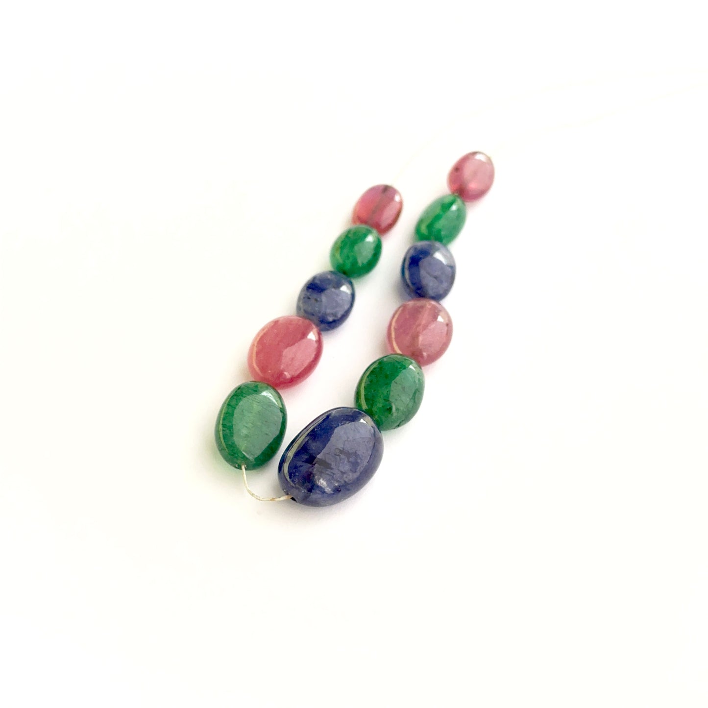 Multi precious smooth oval beads showing ruby, sapphire and emerald colours for handmade jewellery.
