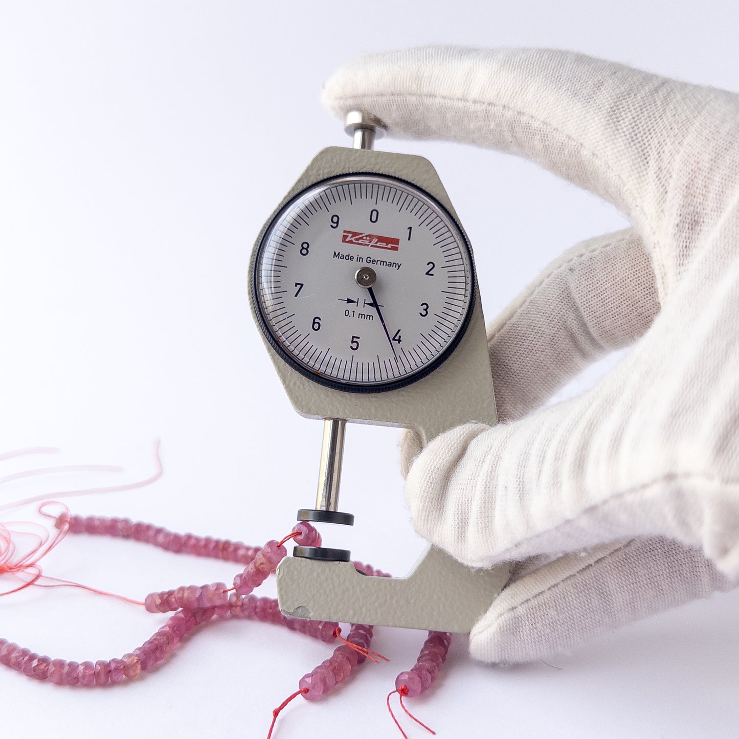 A dial gauge measures the Ruby faceted rondelle 4.2mm gemstone.