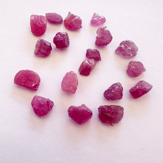 Close-up of raw ruby stones showing uncut surfaces and deep crimson colour.