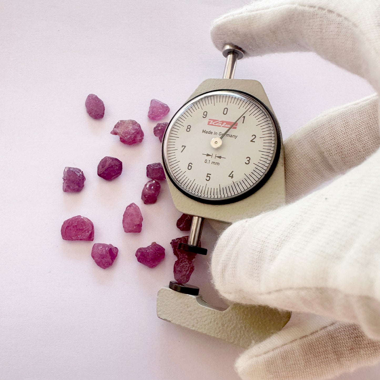 A dial gauge measures the ruby rough cut 8mm gemstone.