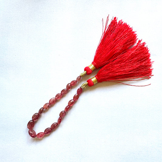 19-piece Ruby gemstone strand laid out to showcase oval cuts and lustrous shine.