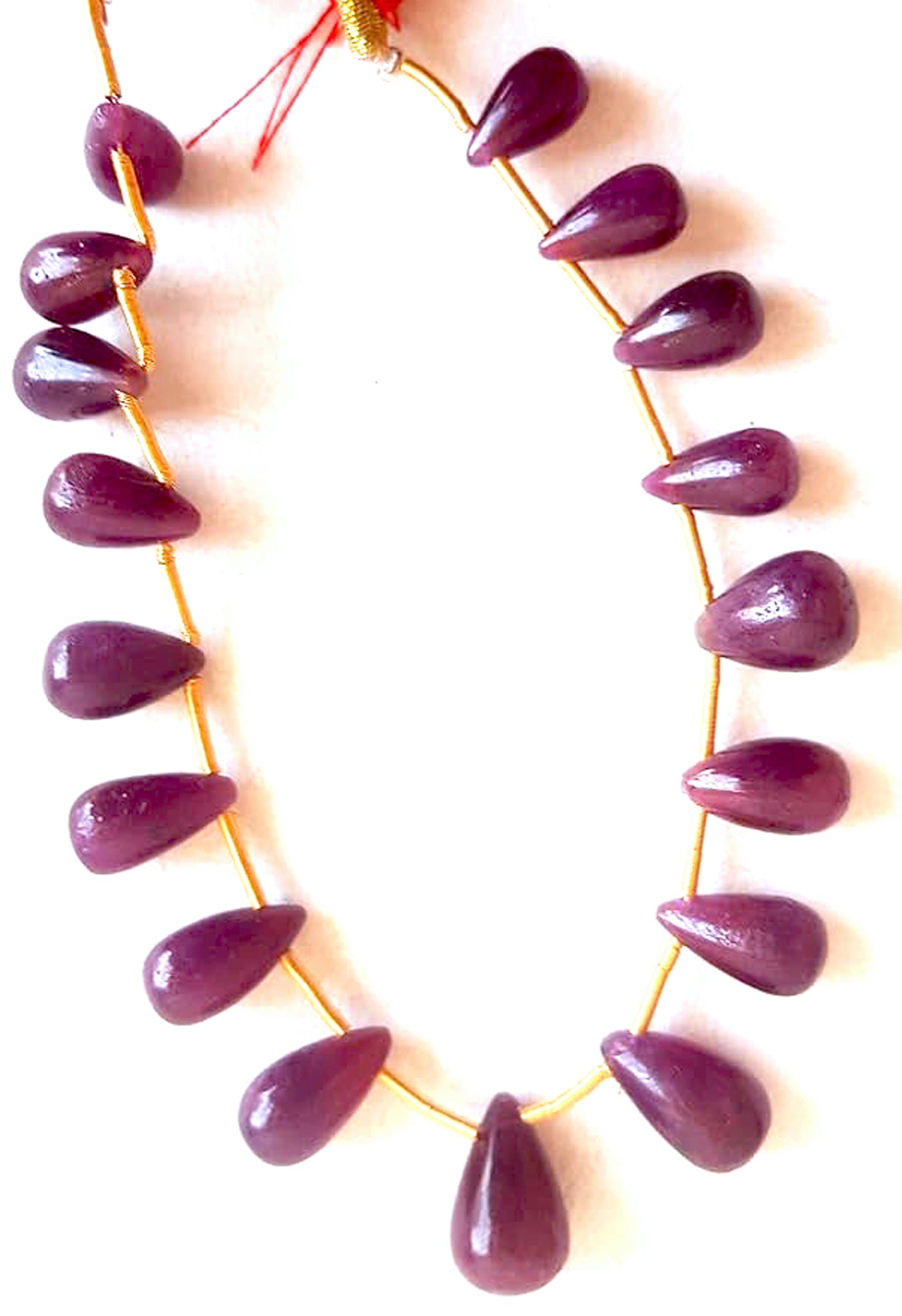 Close-up of ruby teardrop gemstones showing vibrant colour, smooth finish, and consistent bead sizing.