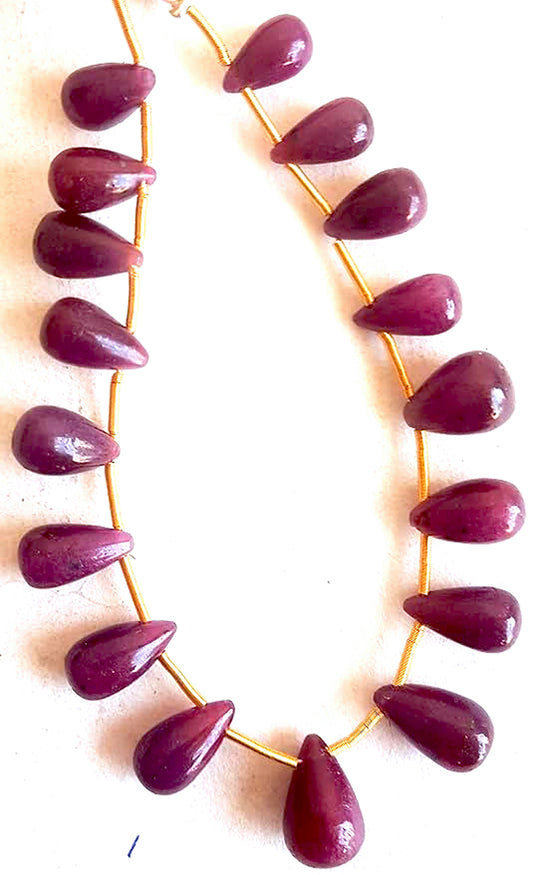 High-quality ruby gemstones with smooth teardrop cut reflect deep crimson hues and natural brilliance.