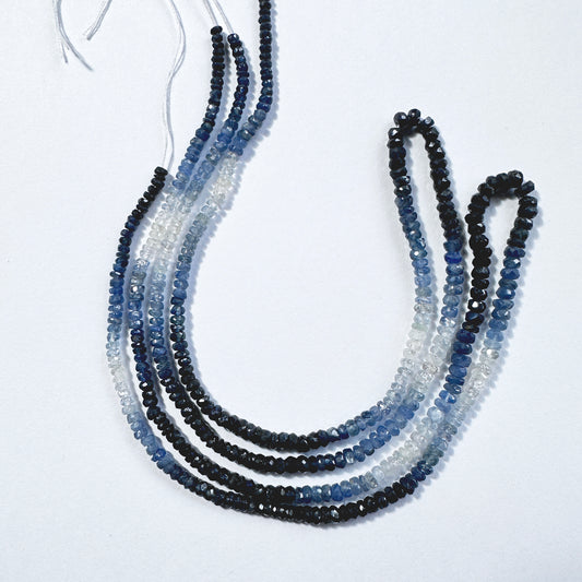 Faceted blue sapphire beads in rondelle cut show deep navy to light blue hues with exceptional clarity and shine.