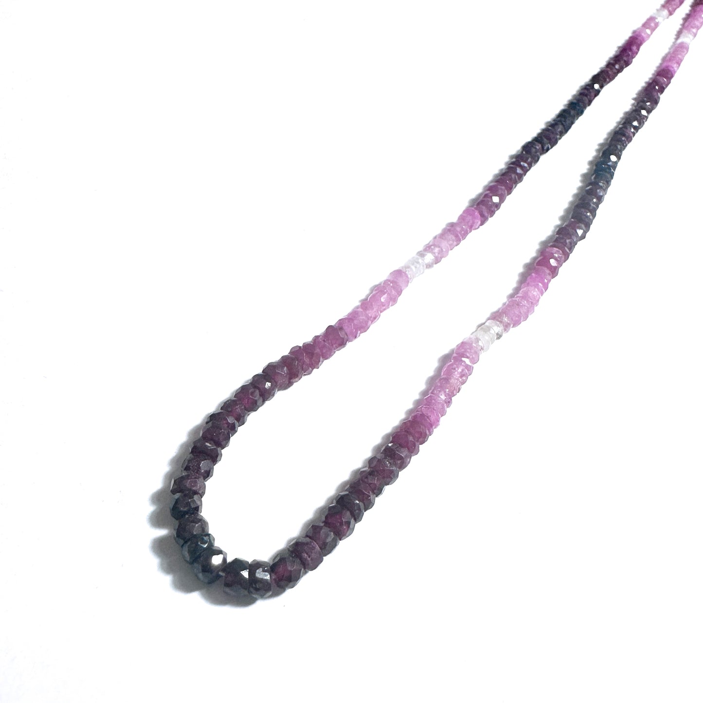 Ruby gemstone beads with faceted rondelle shape reflect light beautifully across the strand.
