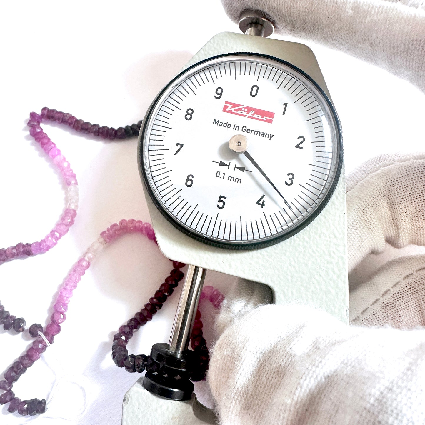 A dial gauge measures the ruby rondelle 3.5mm gemstone for precision and quality.
