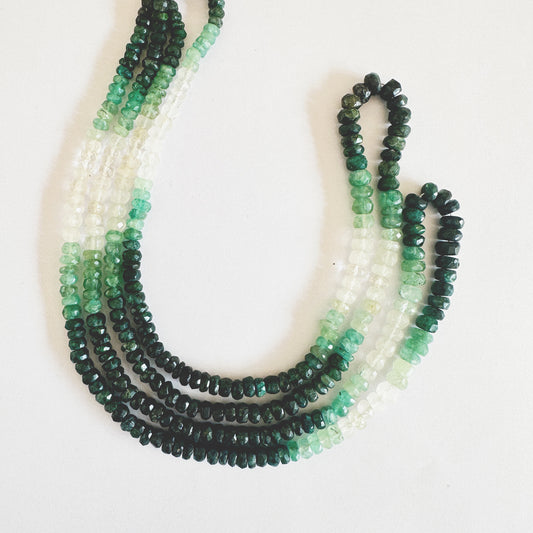Close-up of shaded Emerald gemstone strand showing faceted cuts and elegant colour transitions.