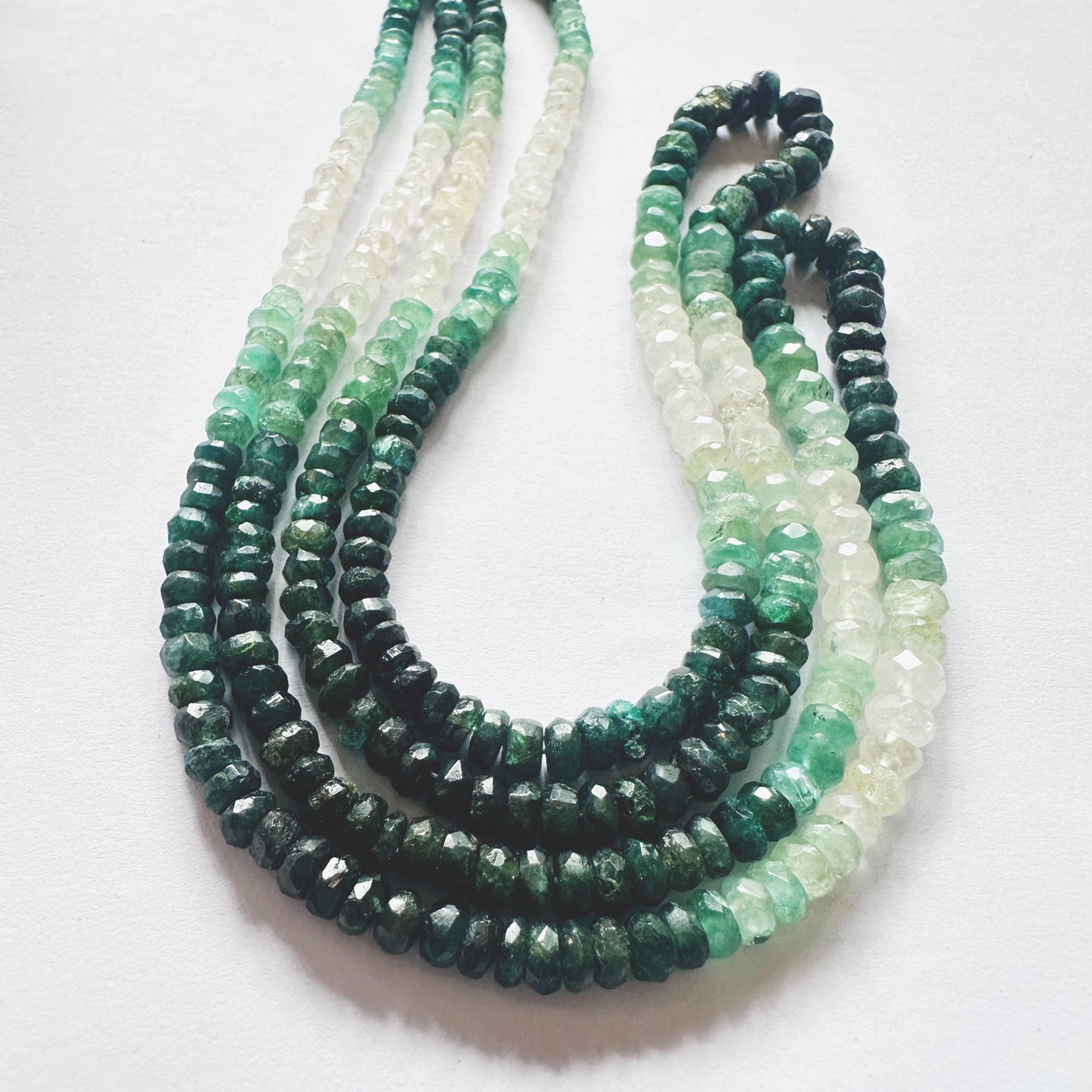 Shaded Emerald gemstones with consistent cut and shine positioned across full strand length.