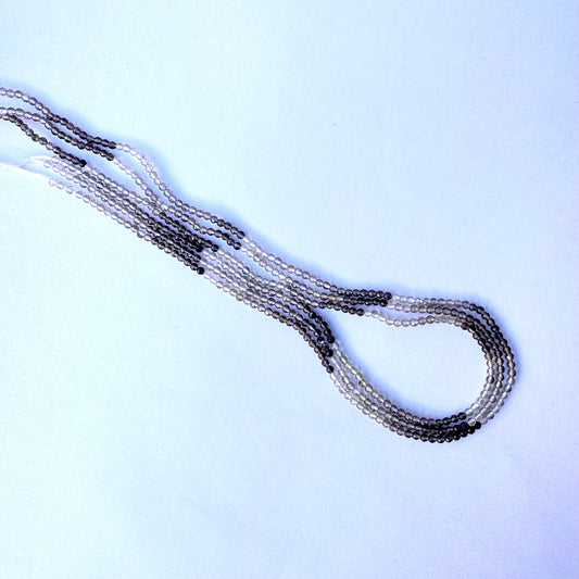 Smoky quartz faceted beads arranged in a neat strand with consistent cut and colour gradient.