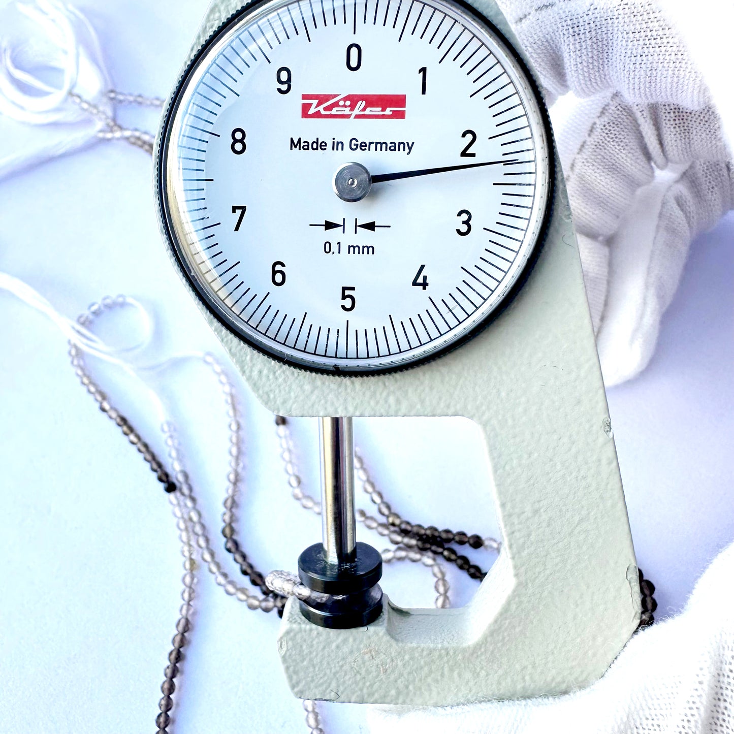 A dial gauge measures the smoky quartz rondelle 2.2mm gemstone.