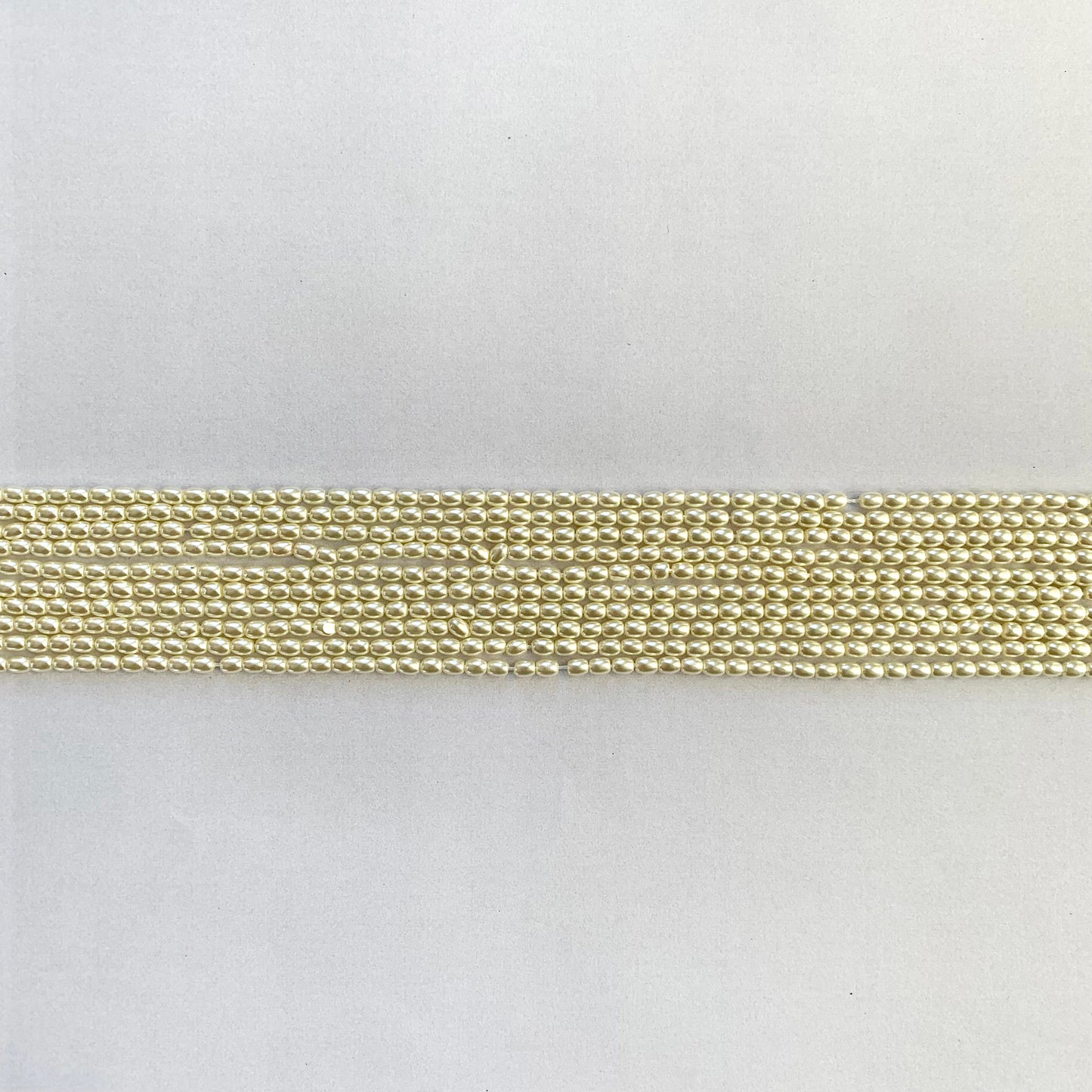 Beautifully arranged pearl strand featuring rice-shaped, white shell beads with gentle shine