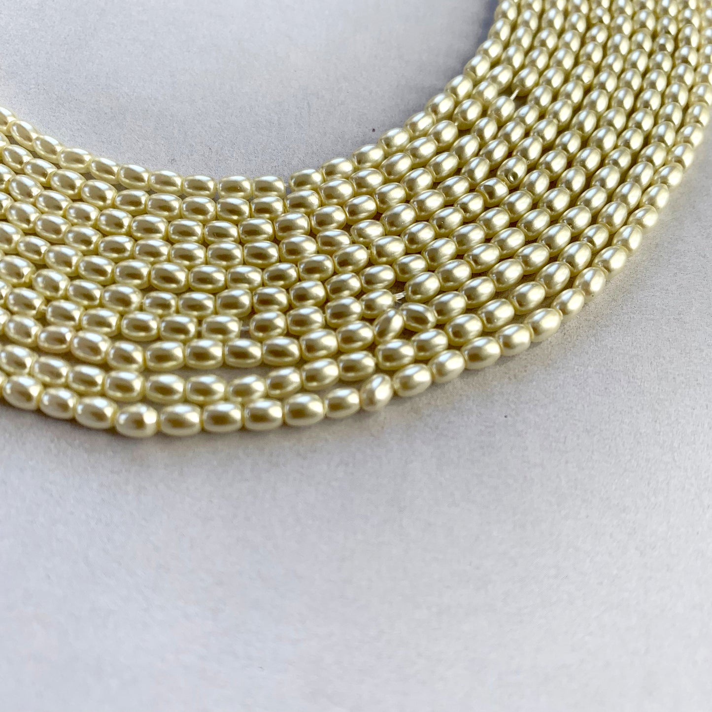 Close-up of 2.7mm rice shell pearls showcasing their smooth polish and subtle shimmer.