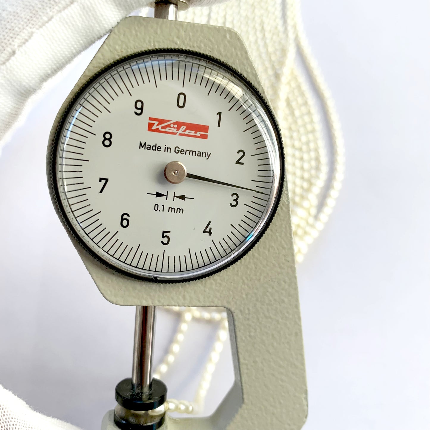 A dial gauge measures the Shell Pearl rice cut 2.7mm gemstone.