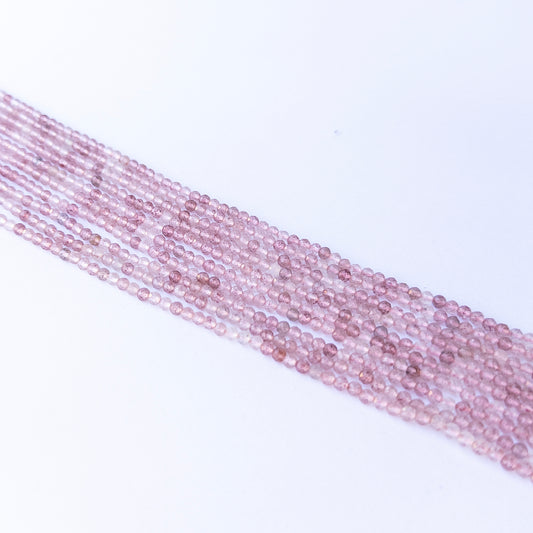 Premium Strawberry Quartz gemstone beads in faceted rondelle cut arranged in strands, showcasing natural pink inclusions for jewellery designers.