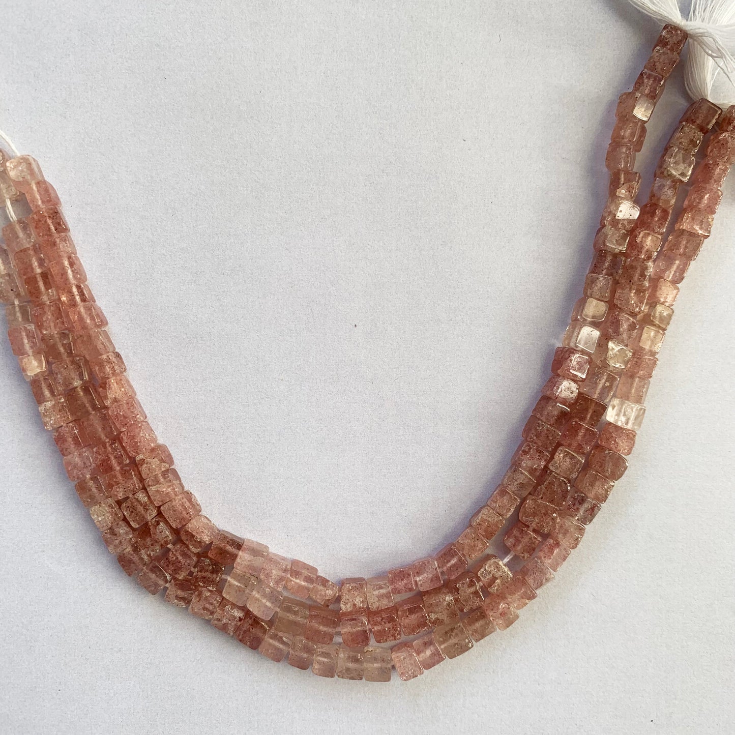 Detailed image of Strawberry Quartz cube beads with visible polish and evenly drilled 0.5mm holes.