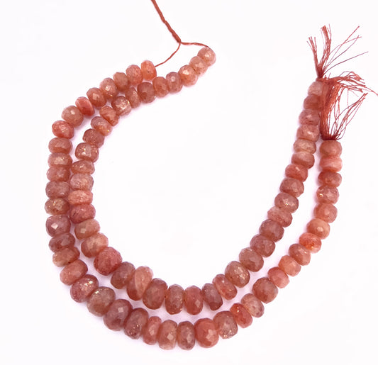 Close-up of Sunstone rondelle beads showing their aventurescence and faceted cut.