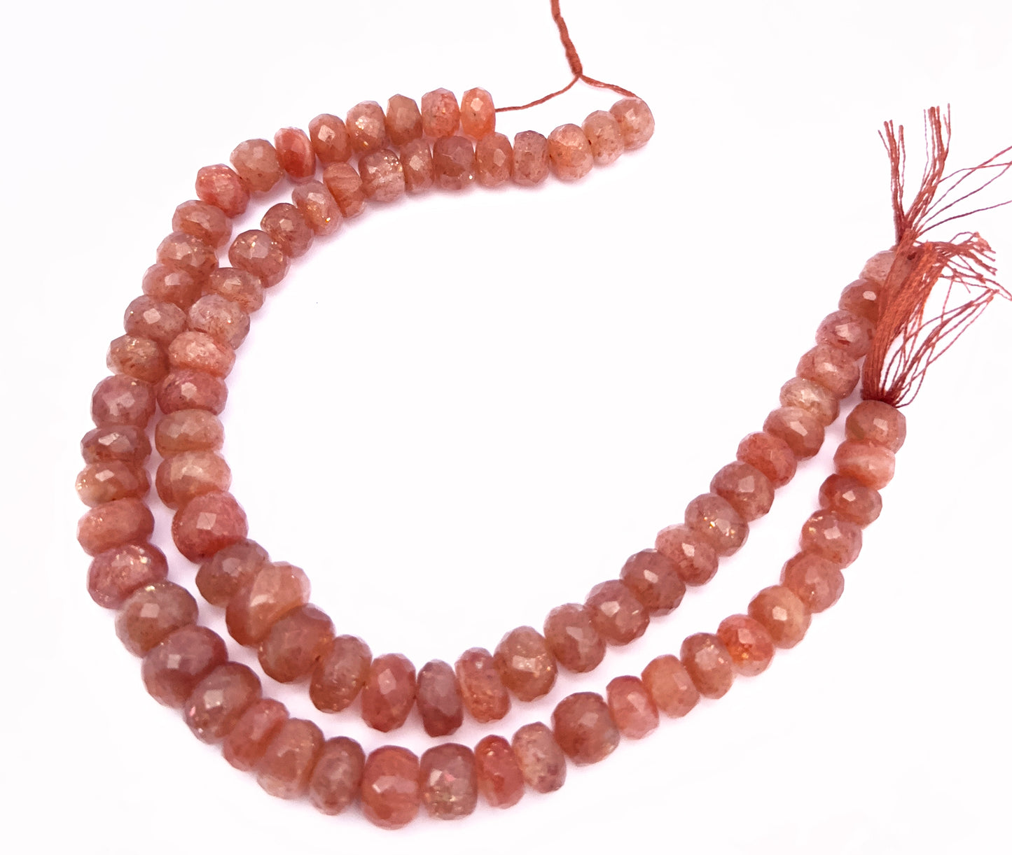 Sunstone gemstone beads laid flat to highlight their rondelle shape and natural shimmer.