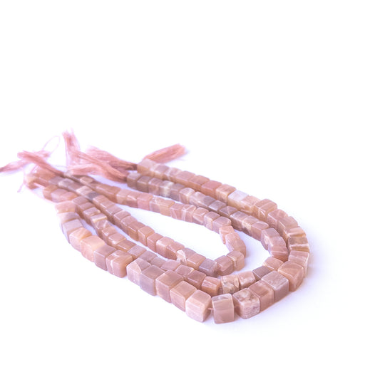 Authentic sunstone gemstone beads showcasing warm peach‑orange tones and uniform cube cuts.