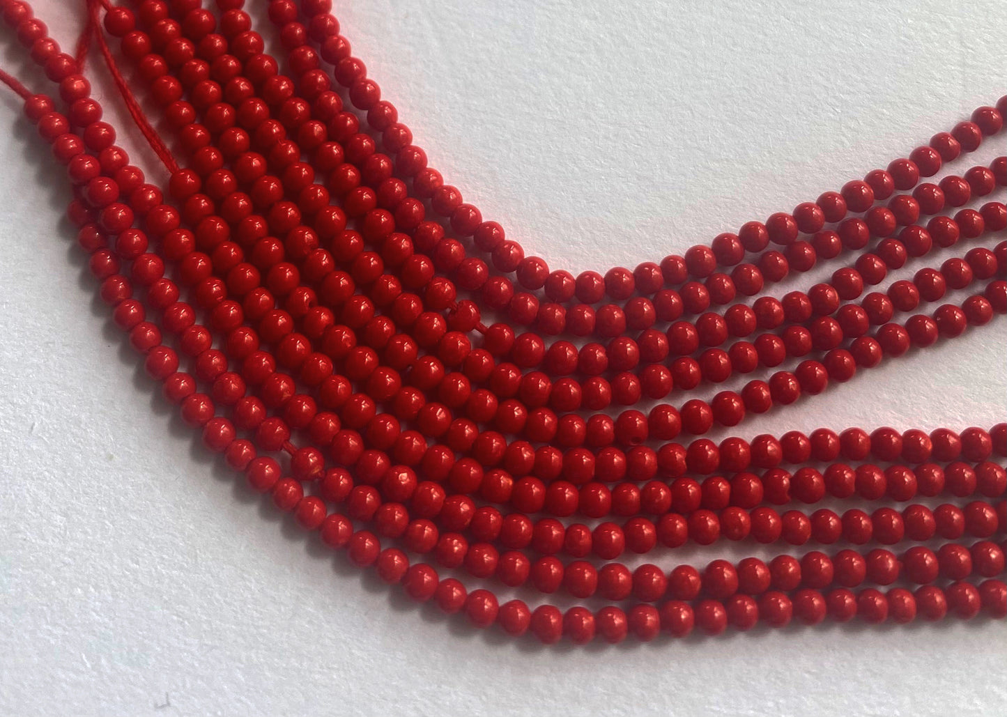 Taiwan Coral beads with intense colour saturation and smooth finish under natural lighting.