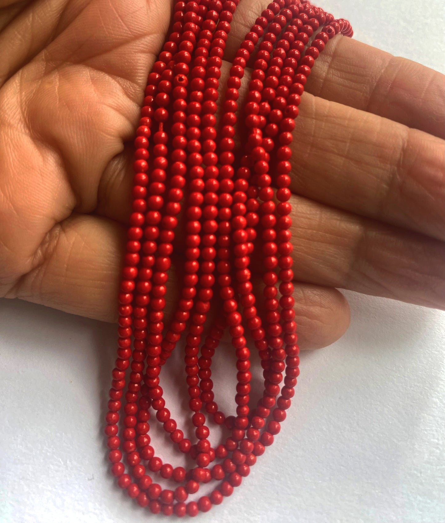 High-quality coral beads with consistent round shape and vibrant hue, laid out for viewing.