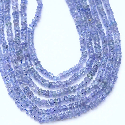 Close‑up of 2.5–2.8mm faceted tanzanite beads arranged on a strand.