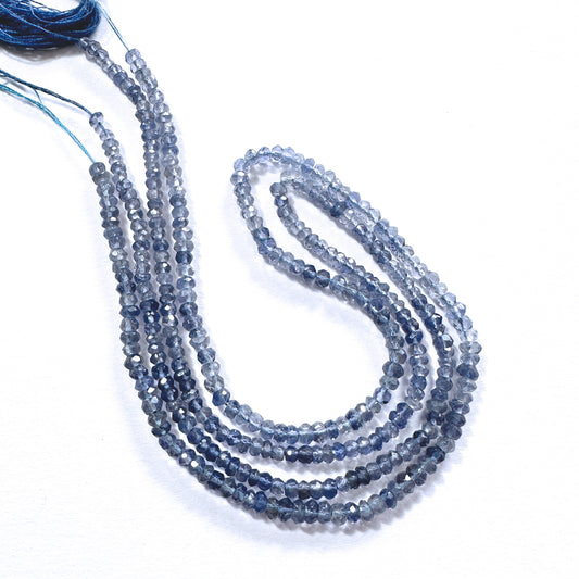 Close-up of 3.5mm tanzanite rondelle beads showing deep violet hues and precision faceting.