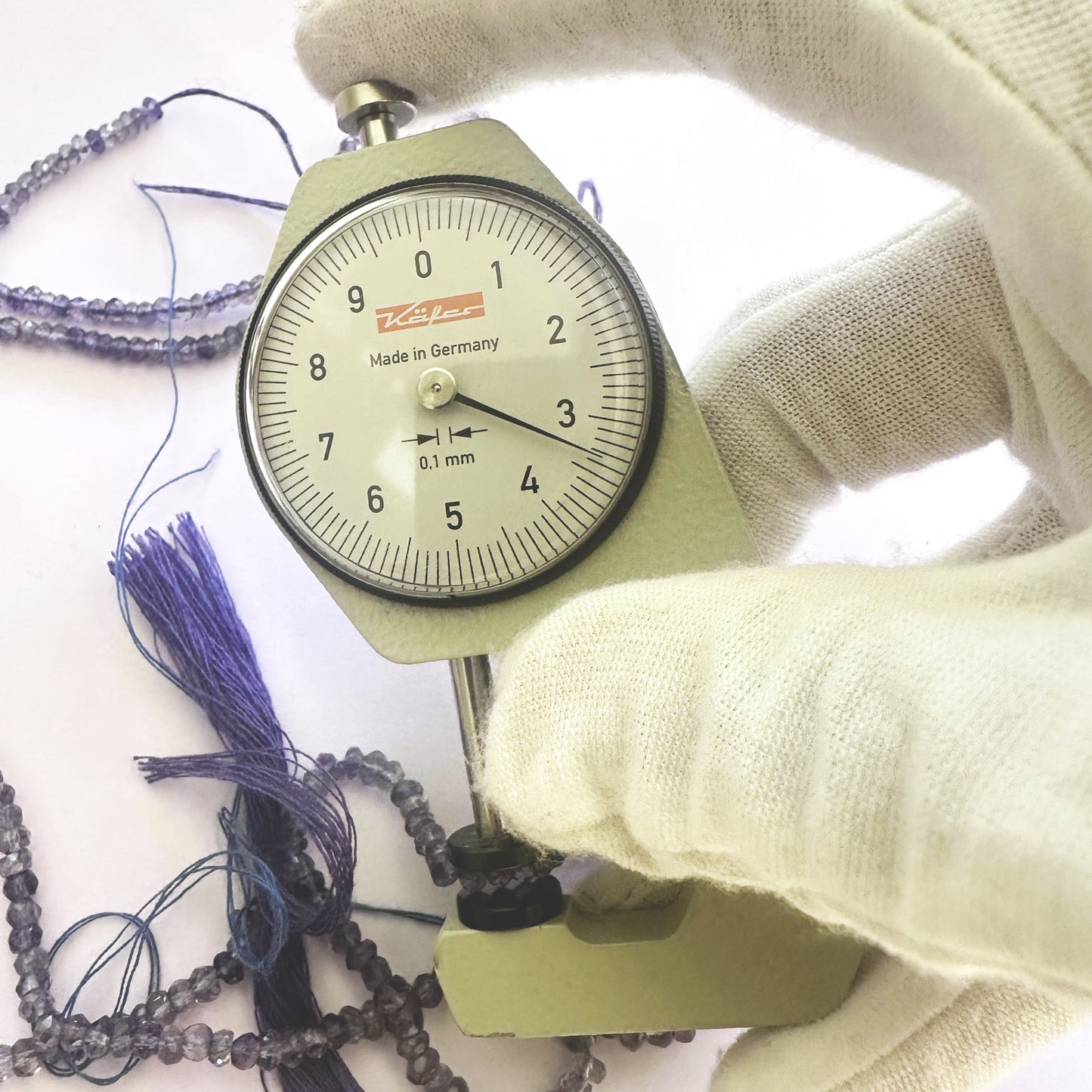 A dial gauge measures the Tanzanite faceted rondelle 3.5mm gemstone.