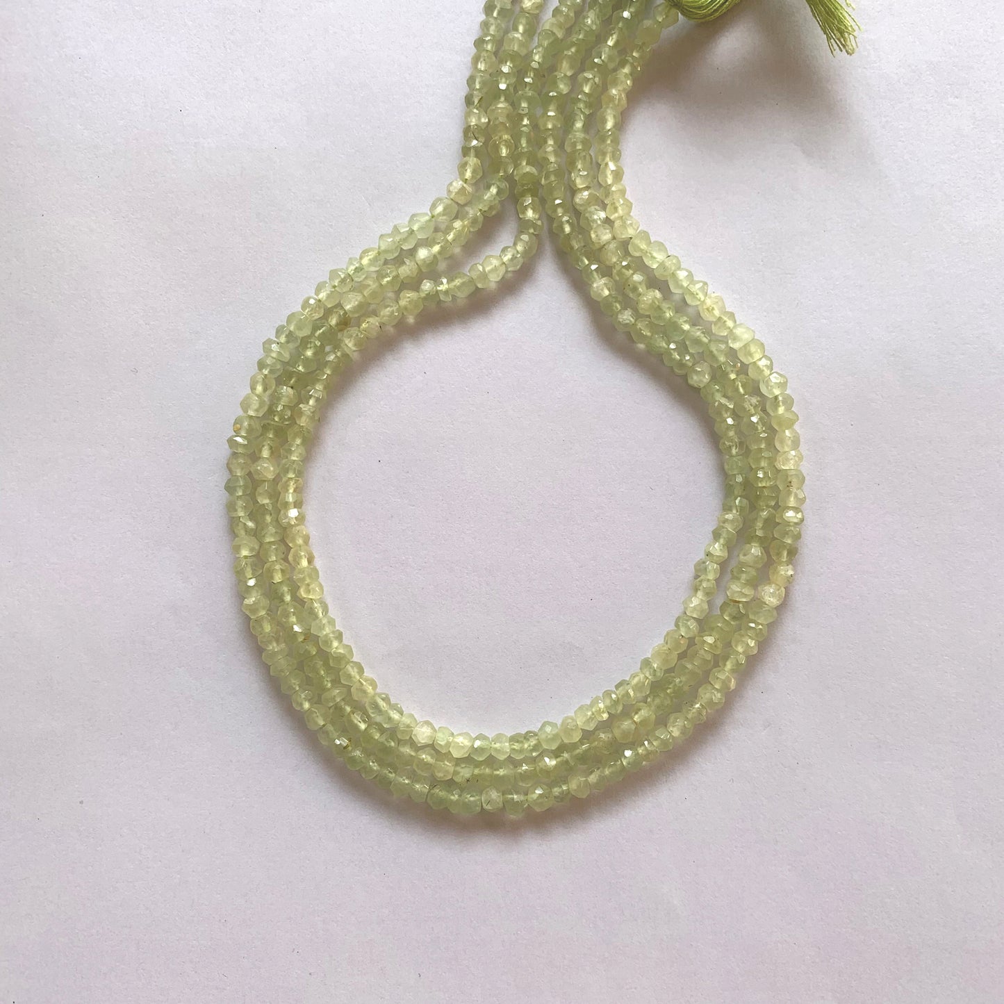 Close-up of Prehnite gemstone beads showing their 4.0–4.2mm size and brilliant faceted cut.
