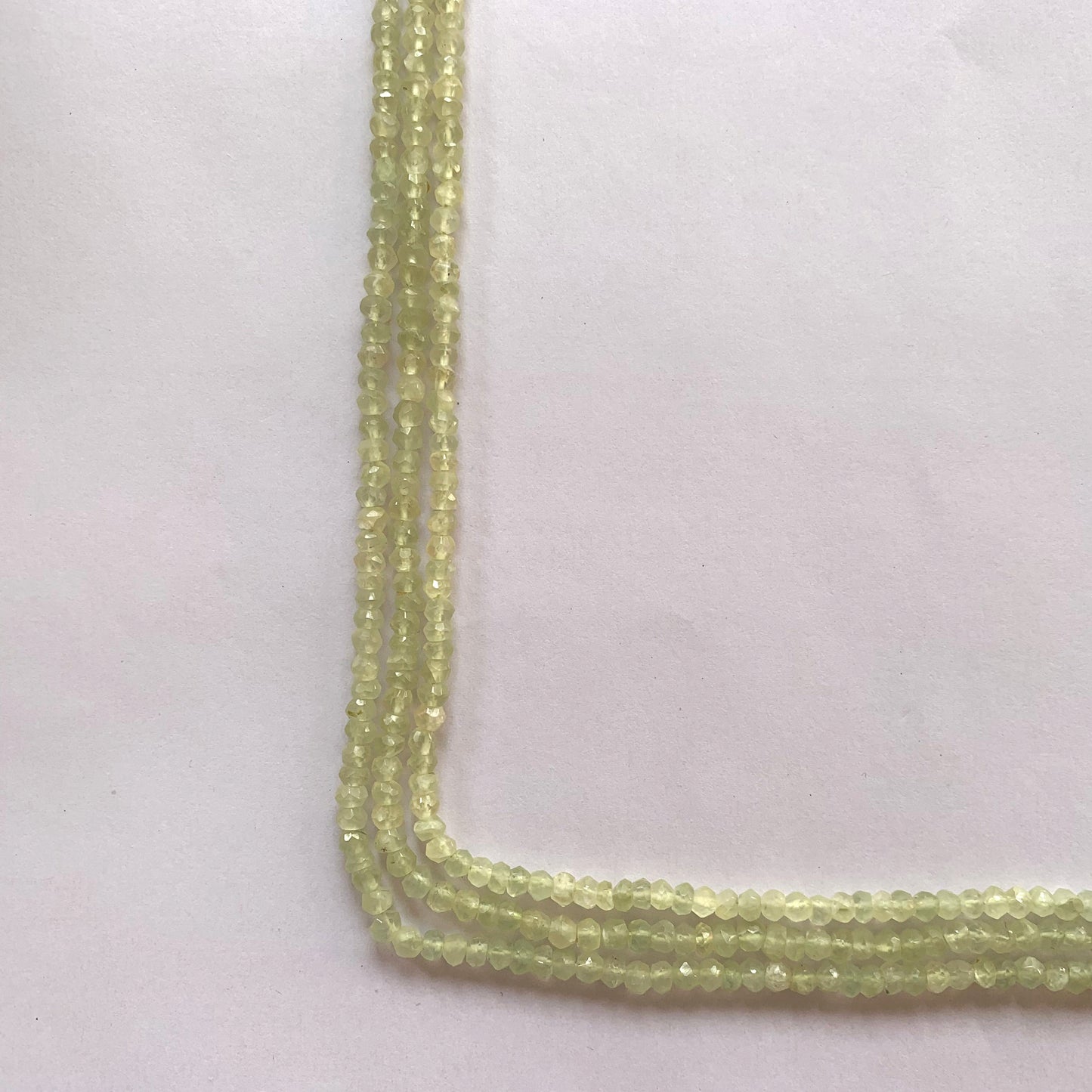 Natural Prehnite rondelle beads with a polished finish, ideal for jewellery making and beading projects.