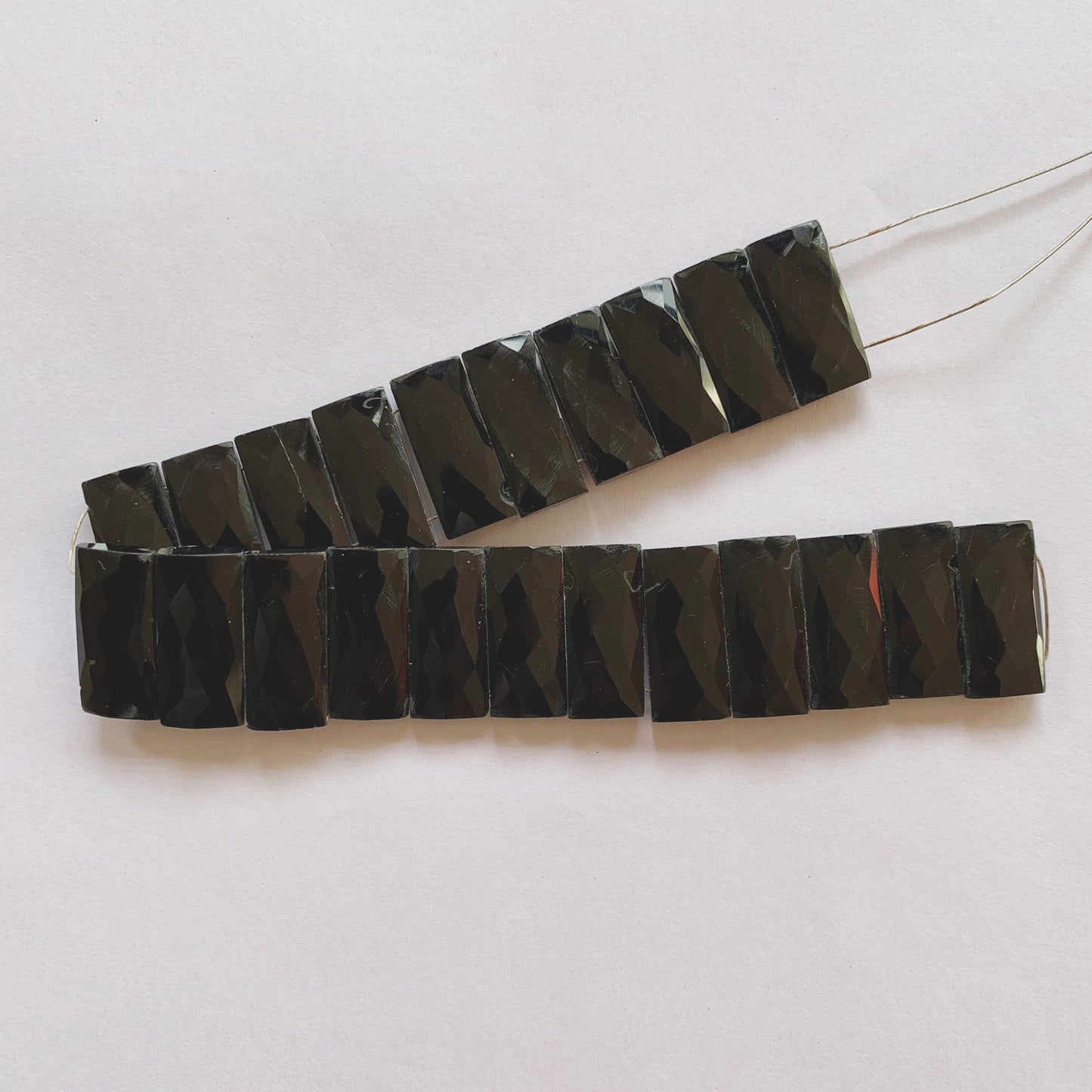 Black Onyx rectangles reflecting light with a glass-like polish, arranged in a neat 20cm strand.