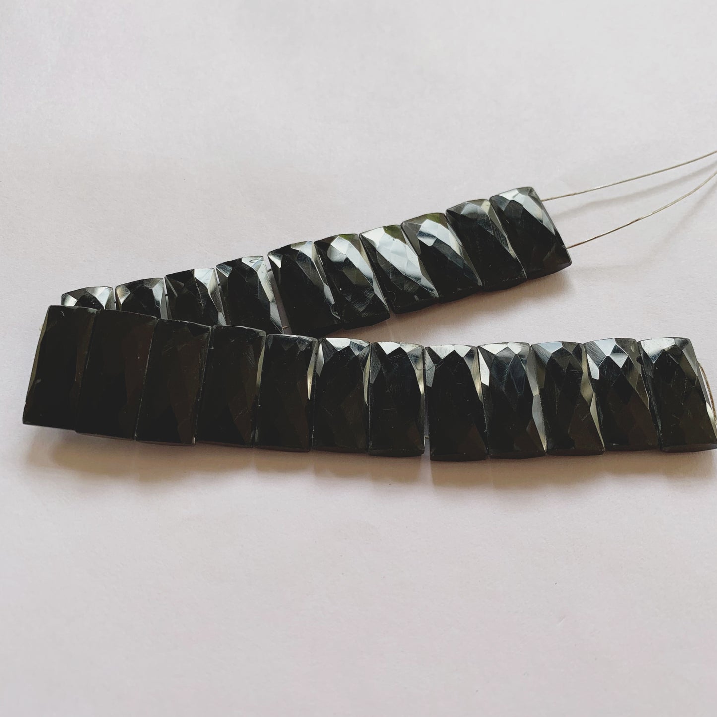 Macro shot of Black Onyx faceted rectangle gemstones showing uniform shape and high shine.