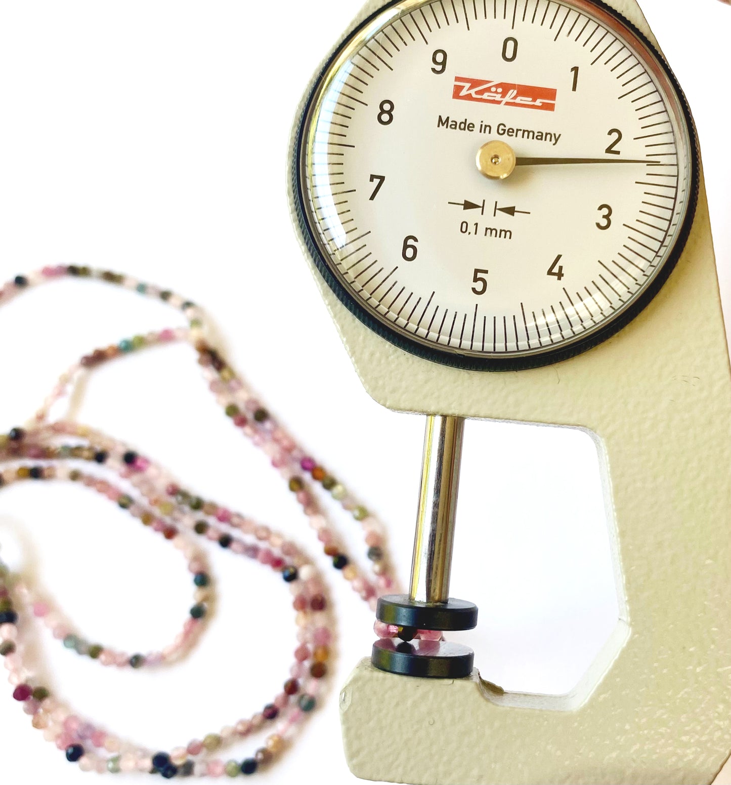 A dial gauge measures the Tourmaline micro faceted 2.3mm gemstone
