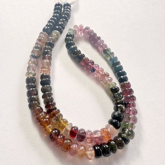 Close-up of tourmaline rondelle beads showing smooth surfaces and rich natural hues.