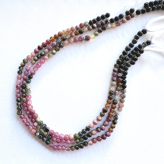 Close-up of natural Tourmaline stone beads showing glossy surface and consistent round cut.