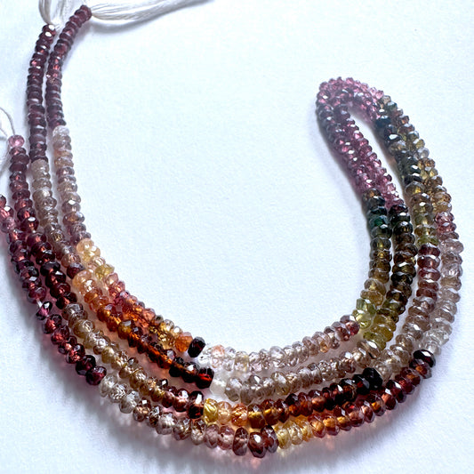 Close-up of Tundra Sapphire rondelle beads showing natural colour variation and precision faceting.