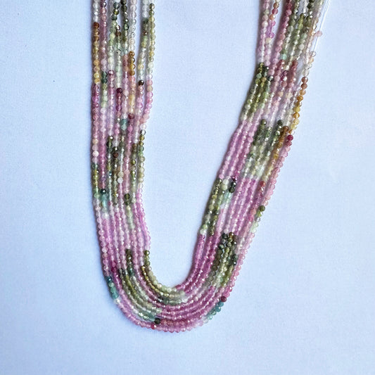 Faceted rondelle watermelon tourmaline beads glistening with natural tones and clear polish.