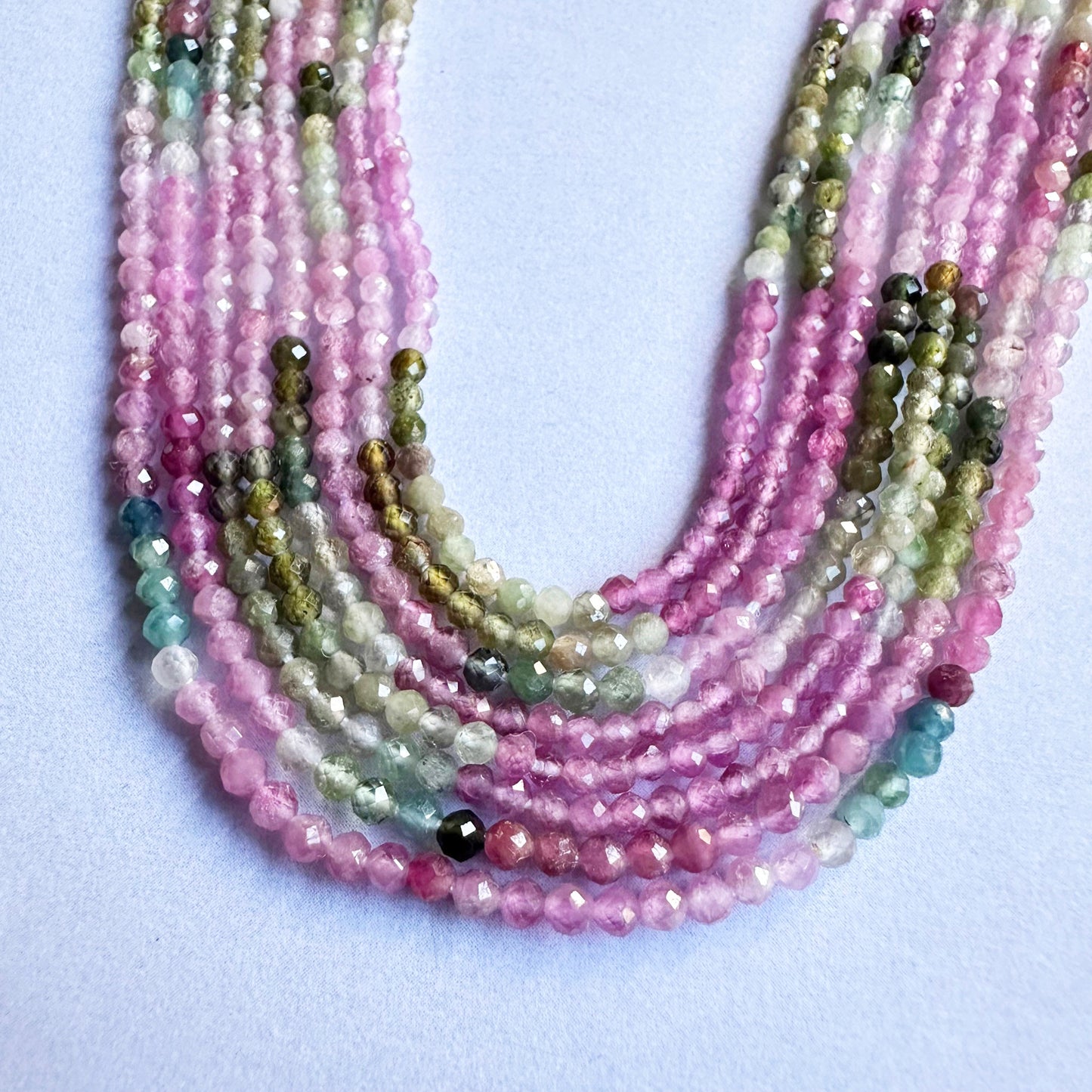 Close-up of watermelon tourmaline faceted rondelle beads showing vivid pink and green hues.