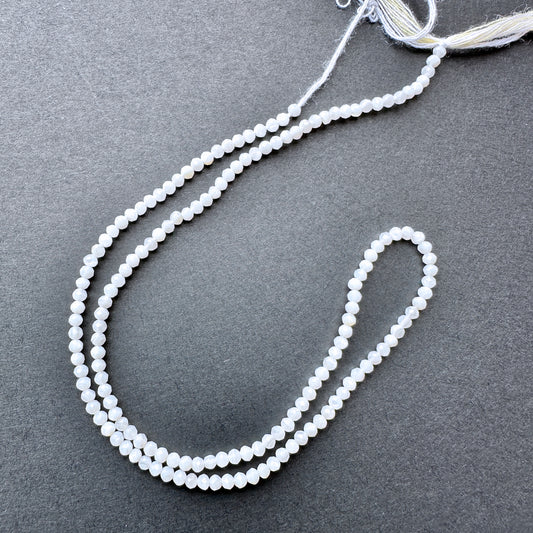 Close-up of White Opal stone beads showing faceted cut and natural gemstone sparkle.