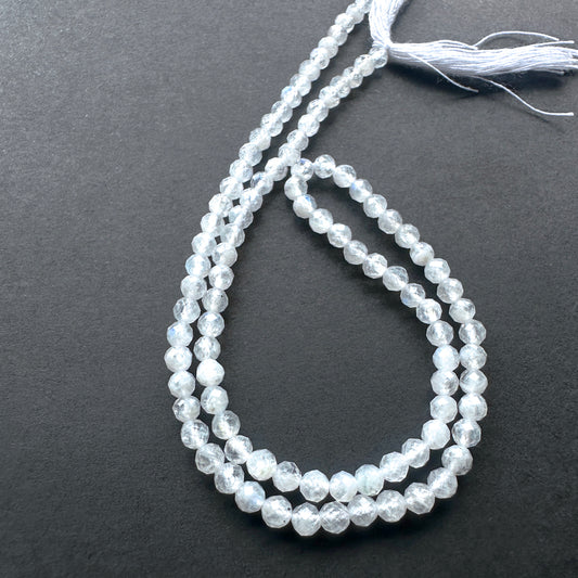 Close-up of White Rainbow Moonstone stone beads showing precise faceting and natural shimmer.