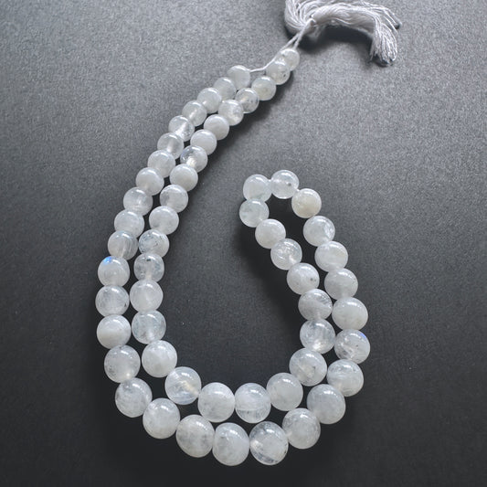 Close-up of White Rainbow Moonstone stone beads showing natural shimmer and smooth surface.