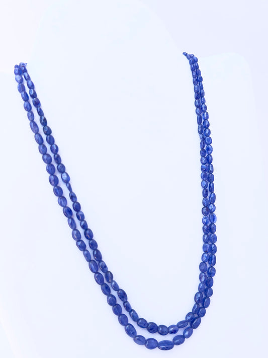 Close-up of Blue Sapphire gemstone beads, smooth oval cut, polished finish, arranged in strands.