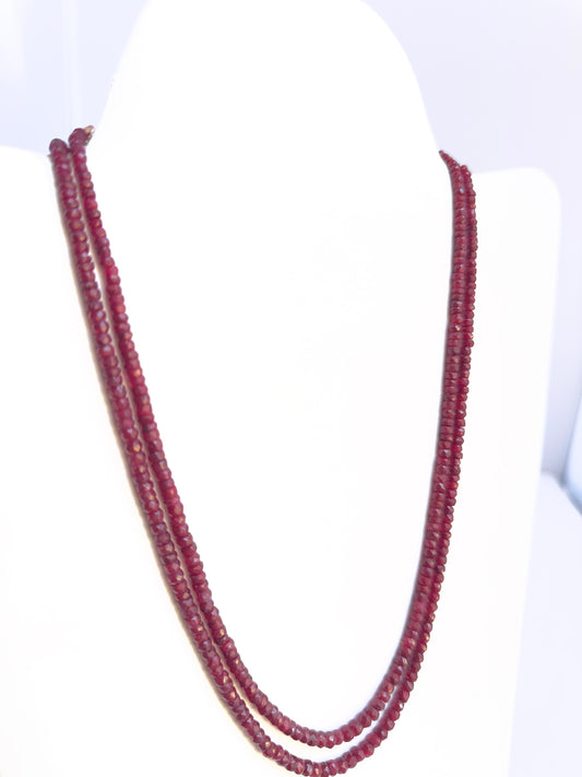 Close-up of Ruby gemstone beads, faceted rondelle cut, sparkling finish, arranged in two strands.