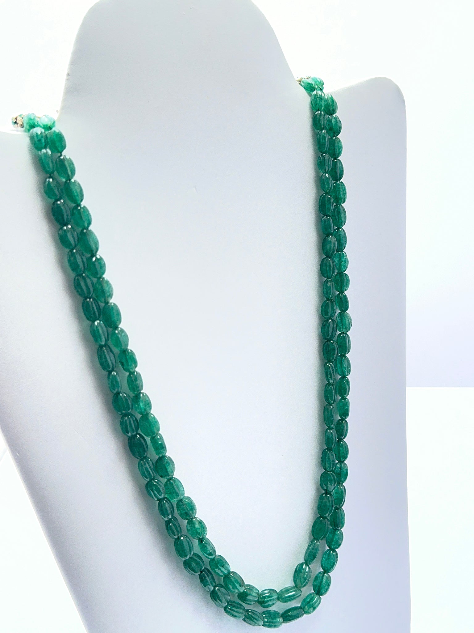 Emerald necklace with carved oval beads showing deep colour and handcrafted detail.