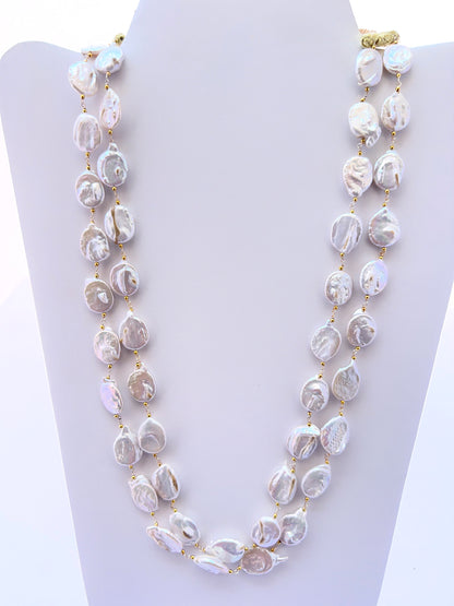 Close‑up of baroque coin pearls arranged on a polished two‑strand necklace.
