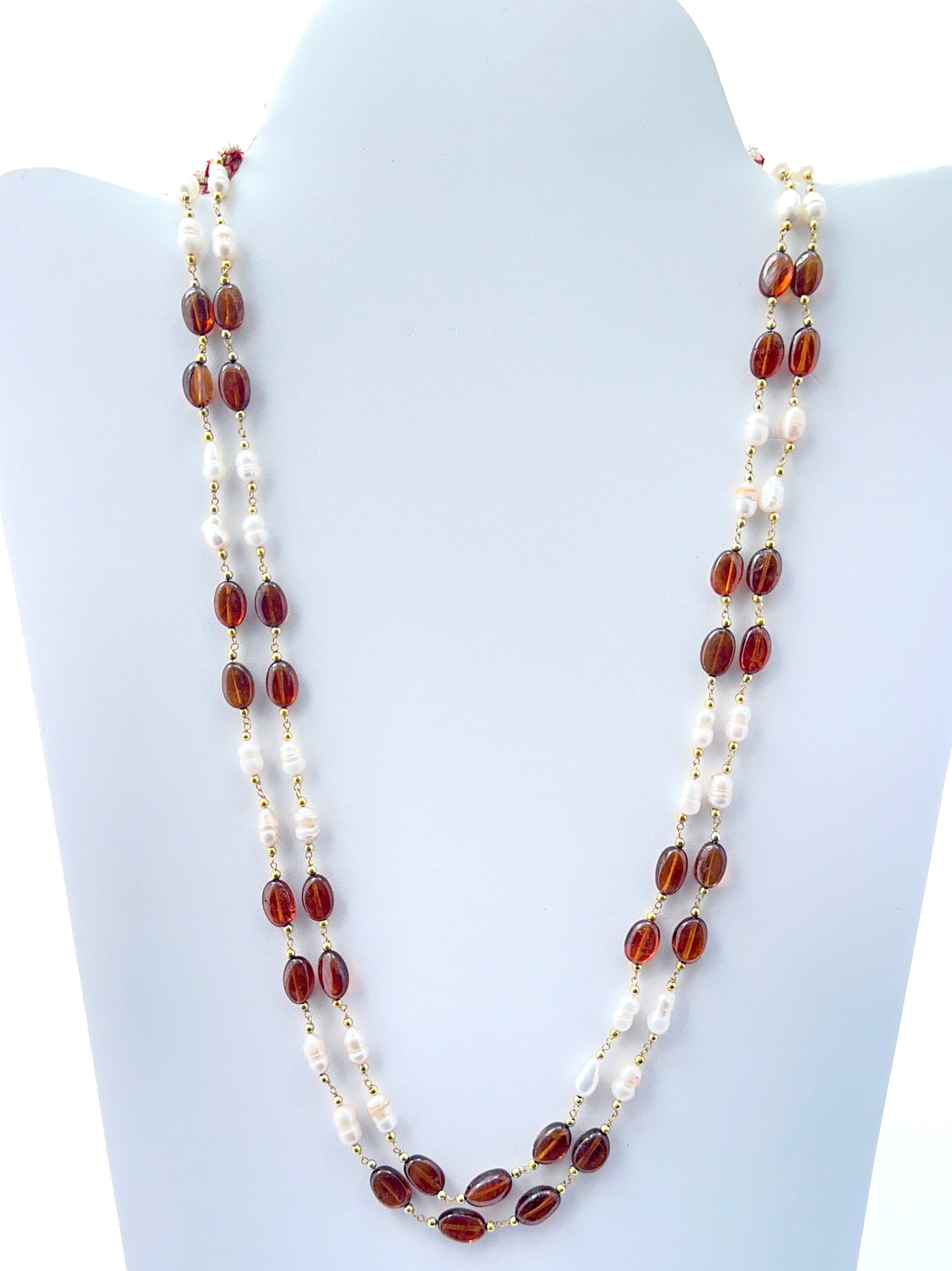 Two‑strand hessonite and freshwater pearl necklace featuring smooth oval beads in warm tones.