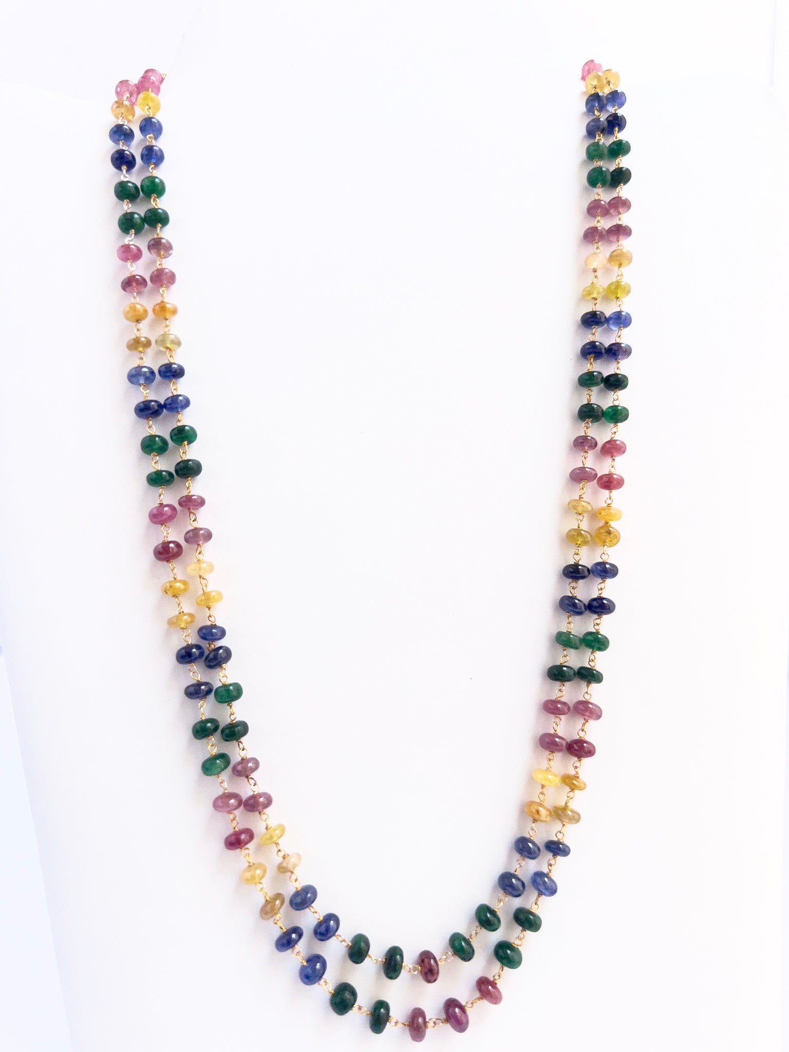 Close-up of multi precious gemstone beads, smooth rondelle cut, polished finish, arranged in strands.