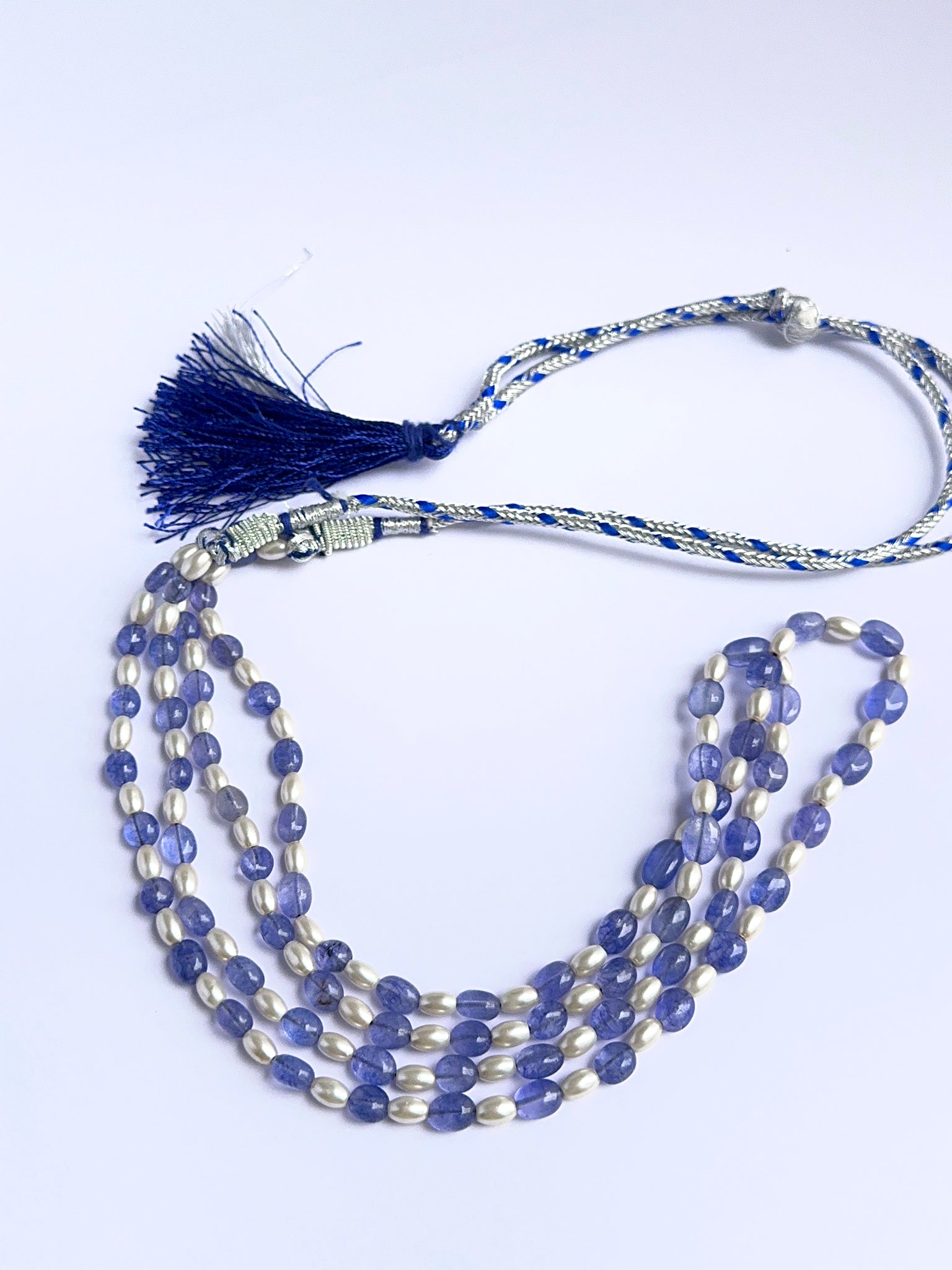 Elegant gemstone necklace featuring quartz and shell pearls in a layered design.