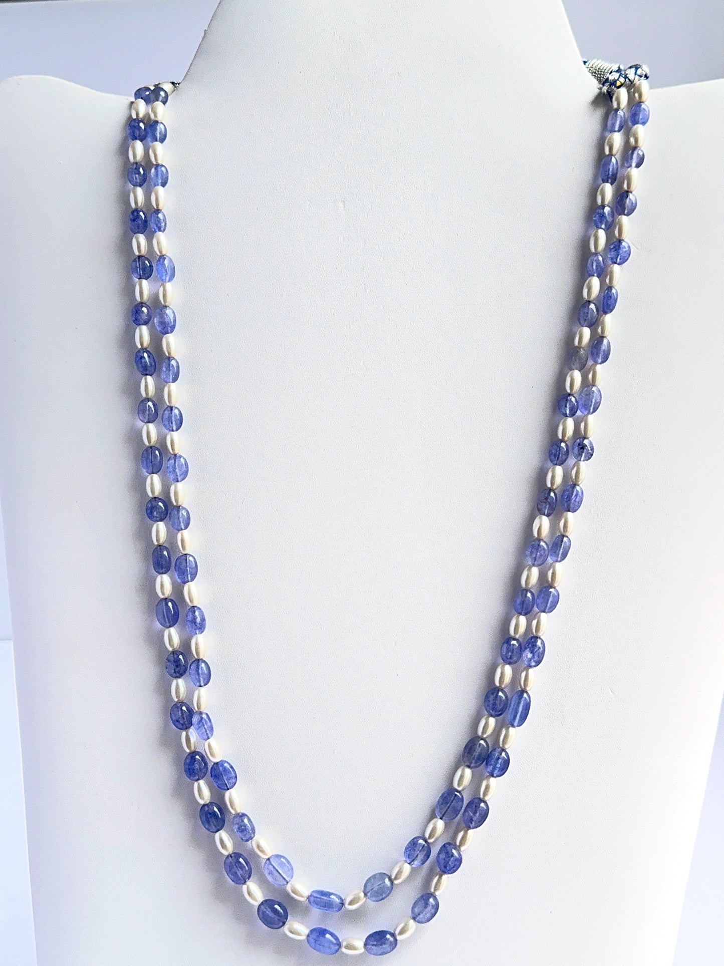 Close‑up of quartz and shell pearl beads arranged on a polished two‑strand necklace.